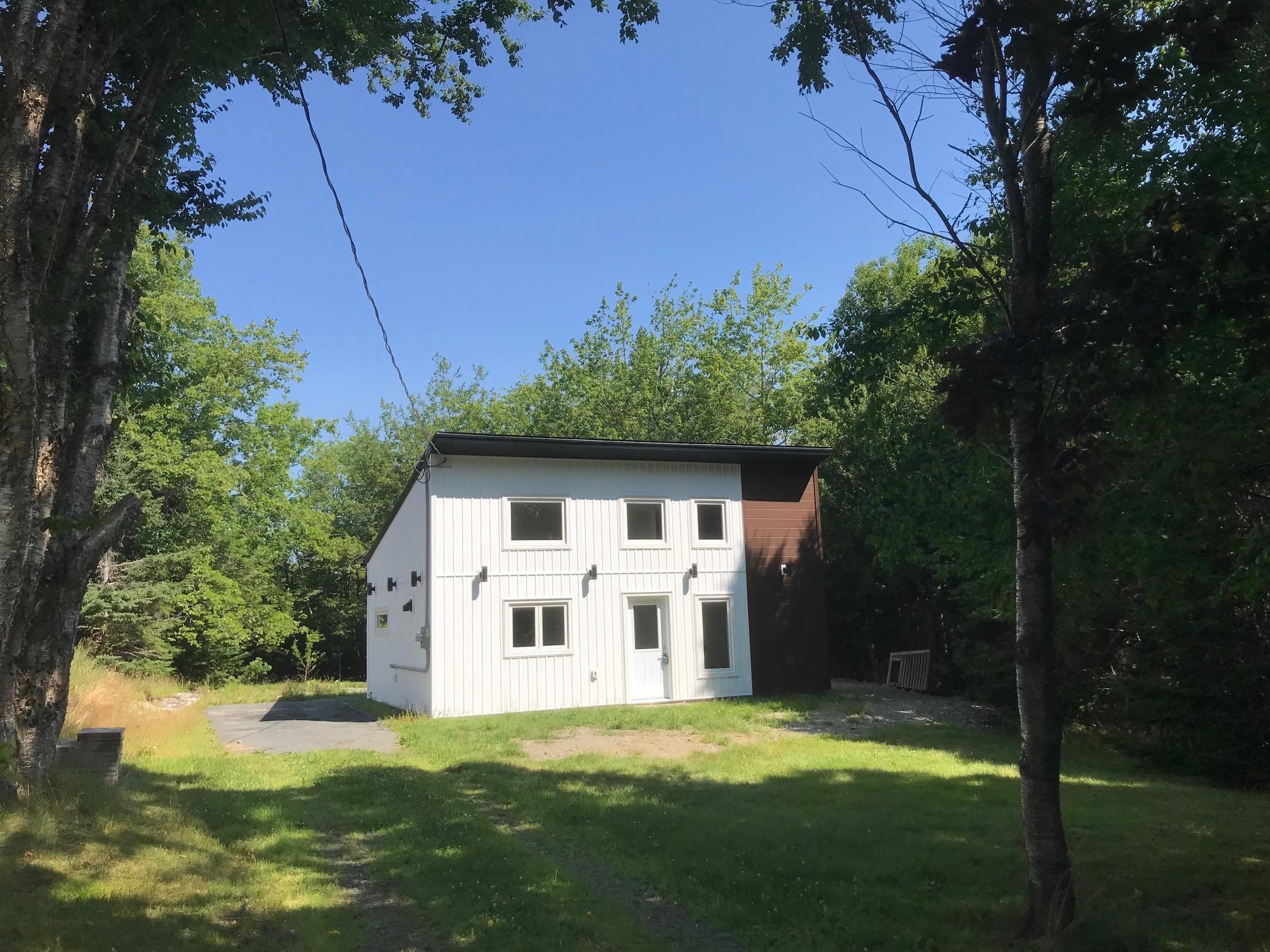 View of front of home with a front lawn and an outdoor structure