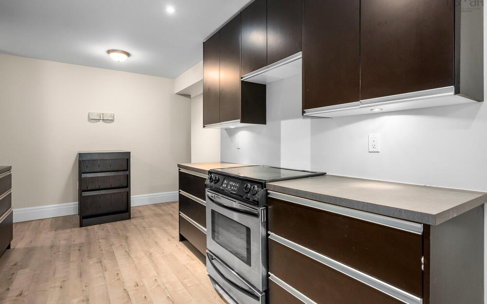 Kitchen featuring stainless steel range with electric stovetop, baseboards, and light wood-type flooring