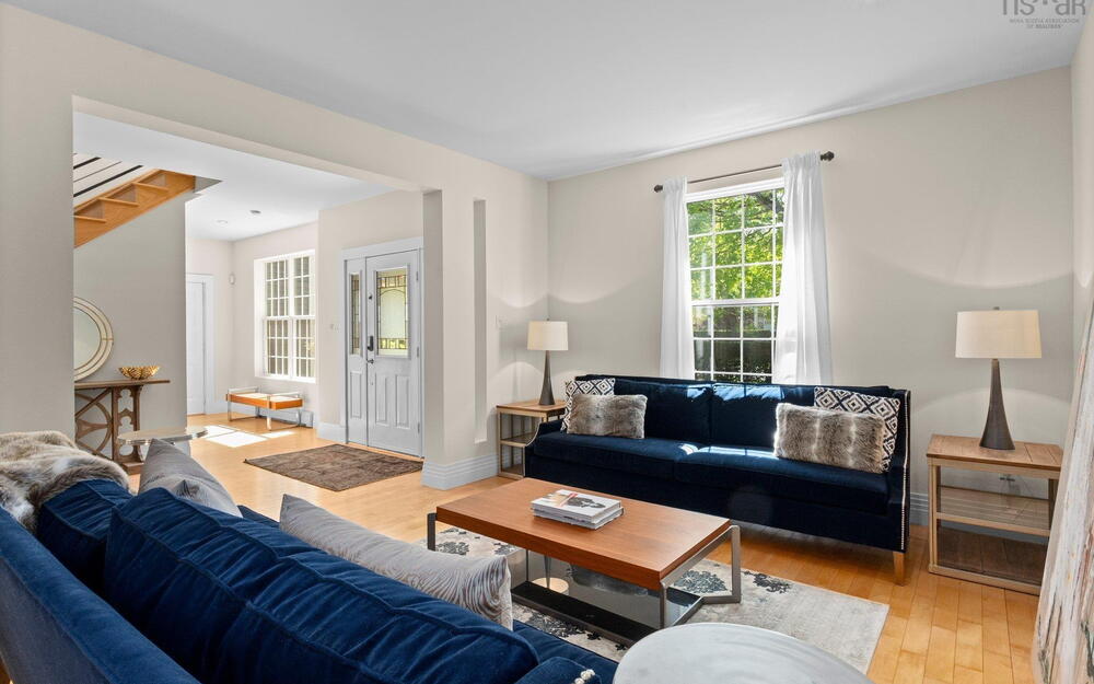 Living room featuring wood finished floors, stairway, and baseboards