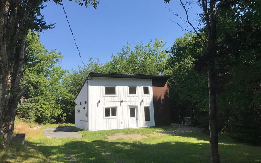 View of front of home with a front lawn and an outdoor structure